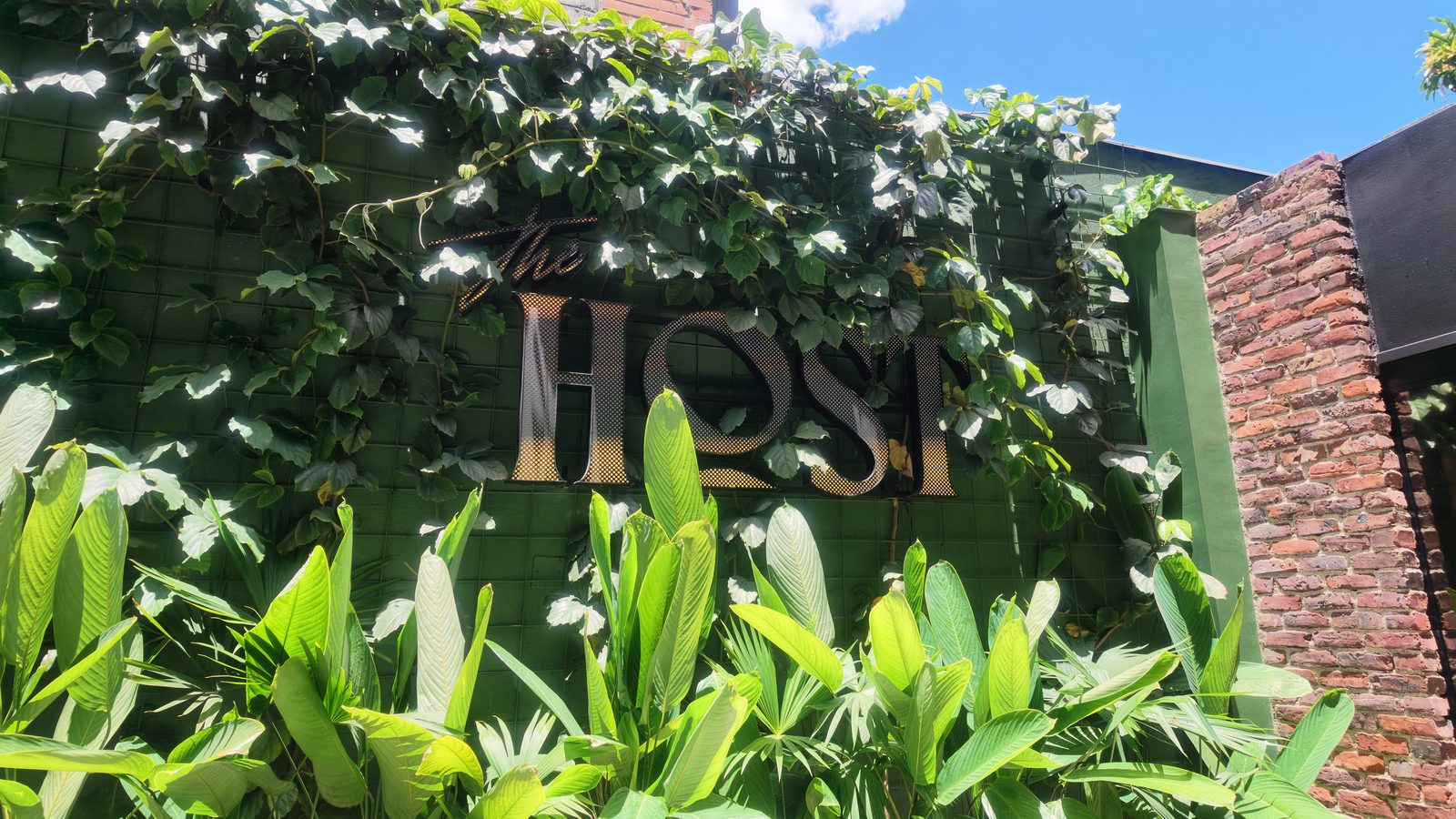 The Host Hotel calle 10 — aviso corpóreo sobre muro verde