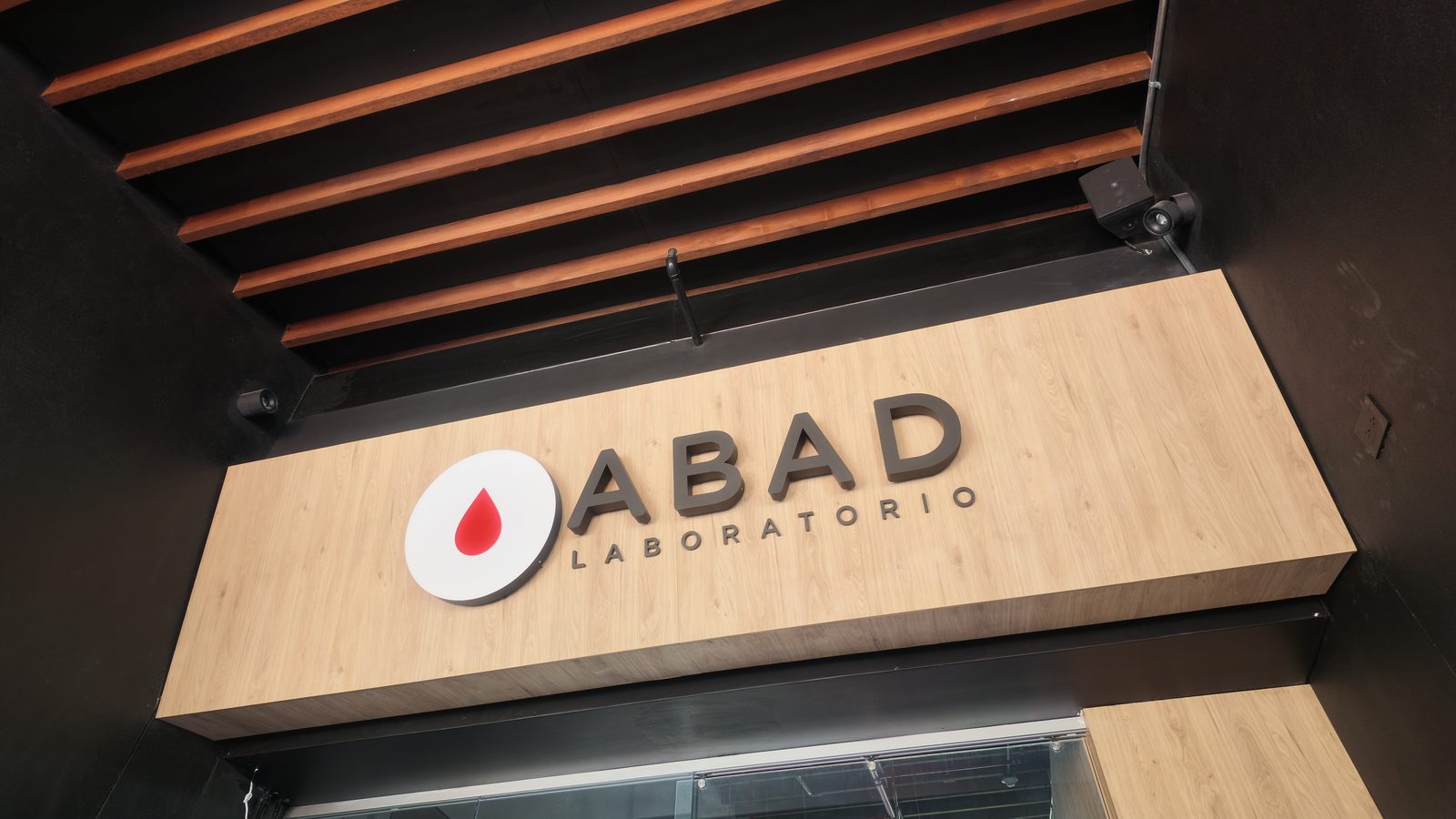ABAD Laboratorio — aviso de fachada en madera